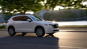 White 2022 Mazda CX-5 driving by a river