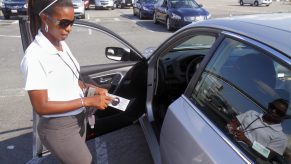 Woman Inspecting Car for Damages or Dents