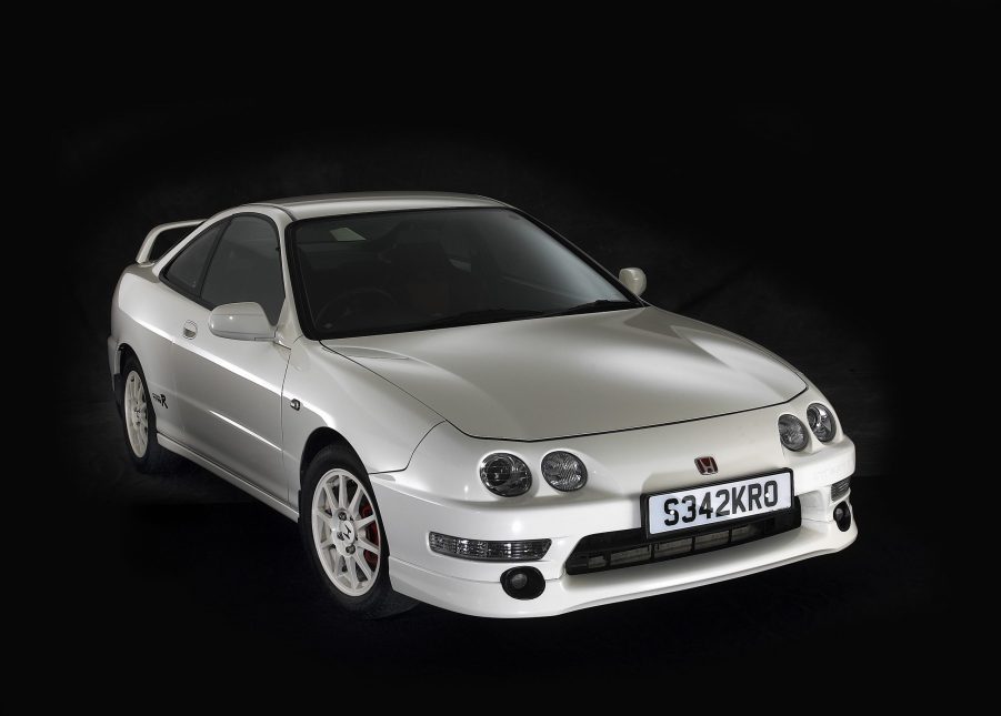 A white Acura Integra Type R shot from the front 3/4 in a black studio