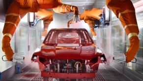 Robotic arms spray paint a car body shell. When buyers order a car from the factory they get to choose the paint color .