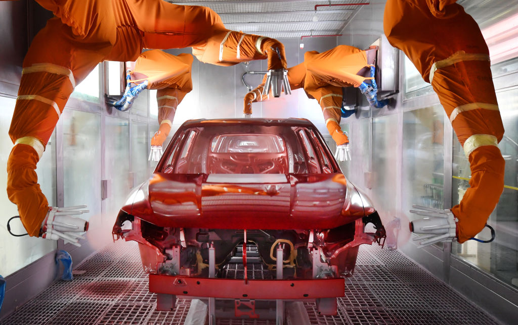 Robotic arms spray paint a car body shell. When buyers order a car from the factory they get to choose the paint color . 