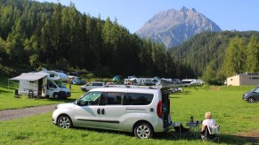 The Dailycamper seen in a field in front of a mountain range. This also happens to be one of the most affordable camper vans on the maket, as well as, a great small camper van