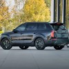 A dark-colored 2021 Kia Telluride sits outside of a house.