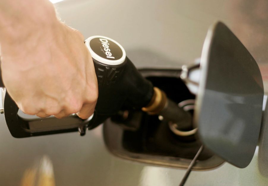 A driver filling up a car at a diesel fuel station