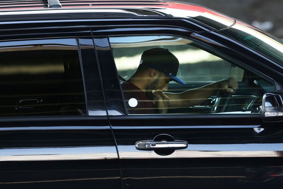 A distracted driver staring at his phone while behind the wheel of a car