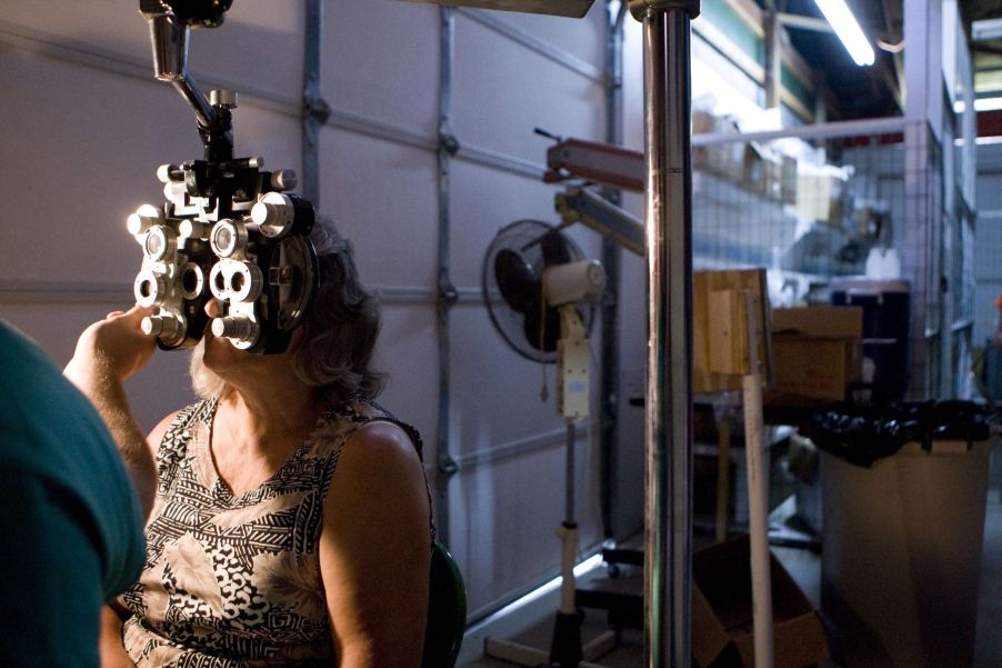 A woman undergoing an eye exam and having her eyes dilated