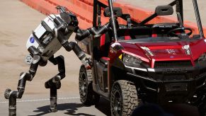 A Nasa robot entering a Polaris vehicle to drive it