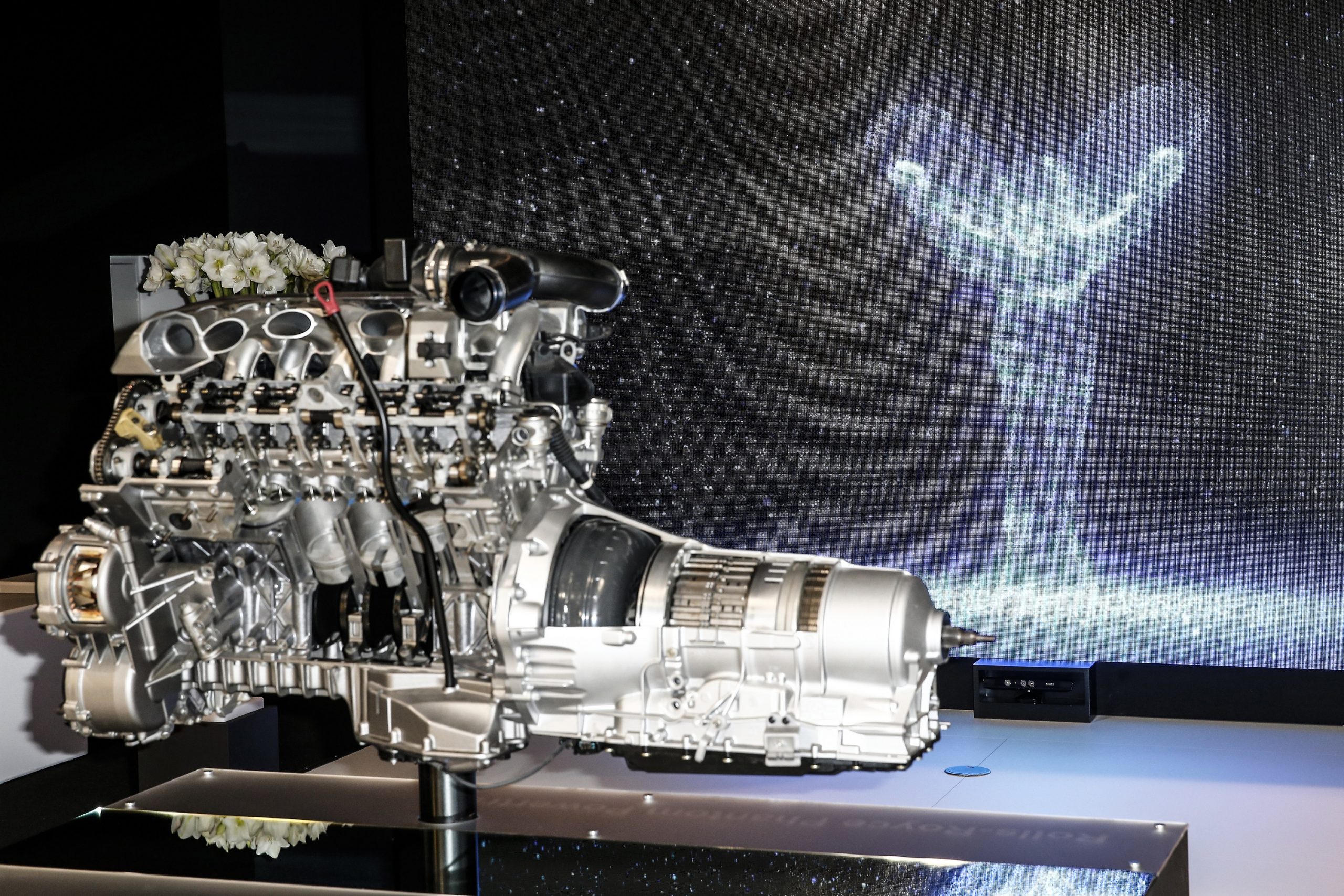 A V12 engine out of one of Rolls Royce's luxury cars on a stand at an auto show