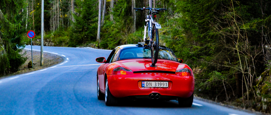 a vacuum mounted bike rack on a porsche driving down the road