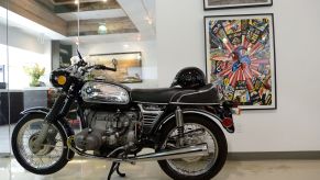 The side view of a black-and-chrome 1970 BMW R75/5 on its center stand in an office building