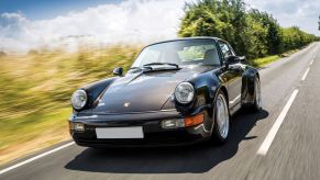 A brown 1993 Porsche 964 911 Turbo 3.6 driving down the road