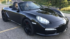 A black 2009 Porsche Boxster S parked in a lot on a hill