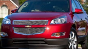 A red 2012 Chevy Traverse parked in a neighborhood.