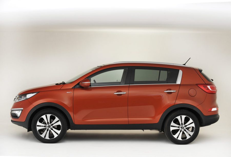 An orange 2013 Kia Sportage with a white background, it is one model year that should be avoided.