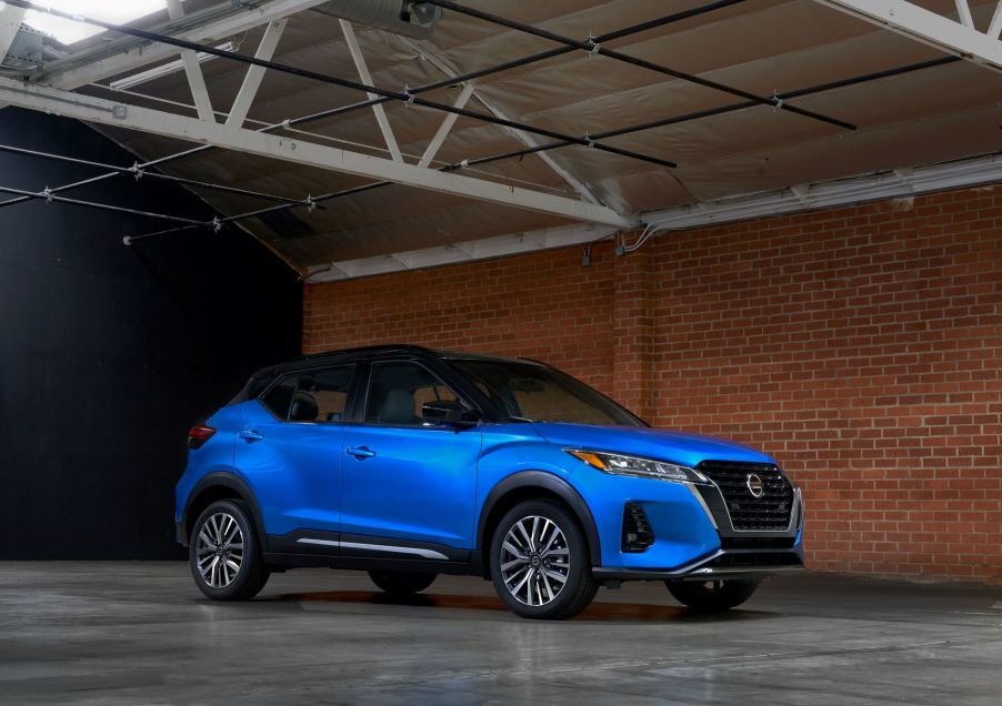 The 2021 Nissan Kicks subcompact SUV with a blue body and black roof parked in a brick warehouse