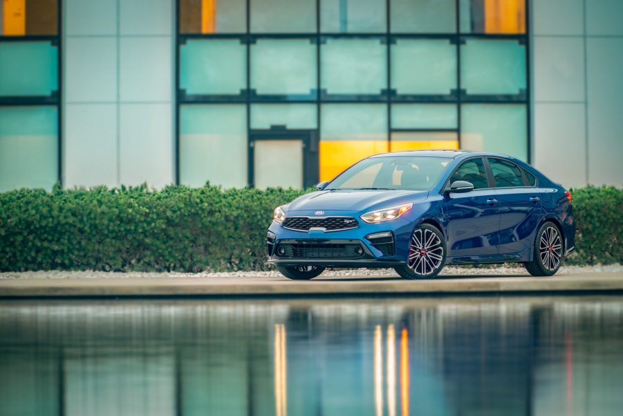 A blue 2021 Kia Forte GT shot in front of a pond from the front 3/4