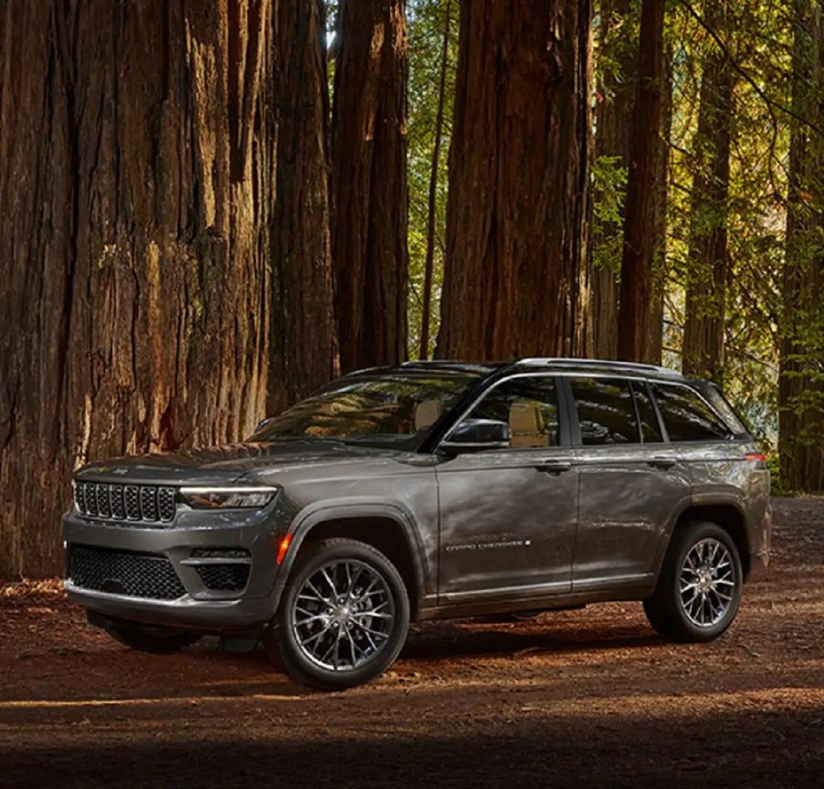 A gray 2022 Jeep Grand Cherokee parked in the woods.