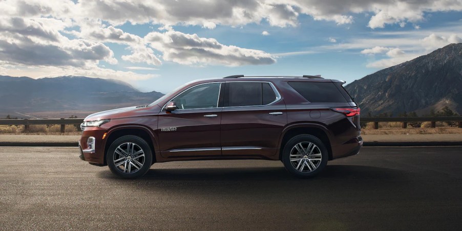 A maroon 2022 Chevy Traverse High Country is parked on the road, it received a few new features this model year.