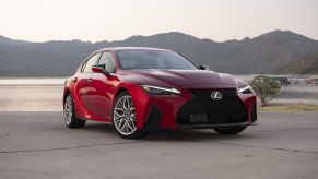 A red 2022 Lexus IS 500 F Sport on a concrete area with hills behind it.