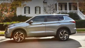 A silver 2022 Mitsubishi Outlander parked in front of a house.