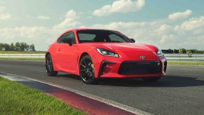 2022 Toyota GR86 in red driving on a track toward the right side of the image frame.