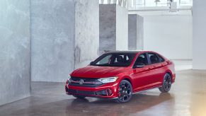 A red 2022 Volkswagen Jetta GLI shot from the front 3/4 in a warehouse