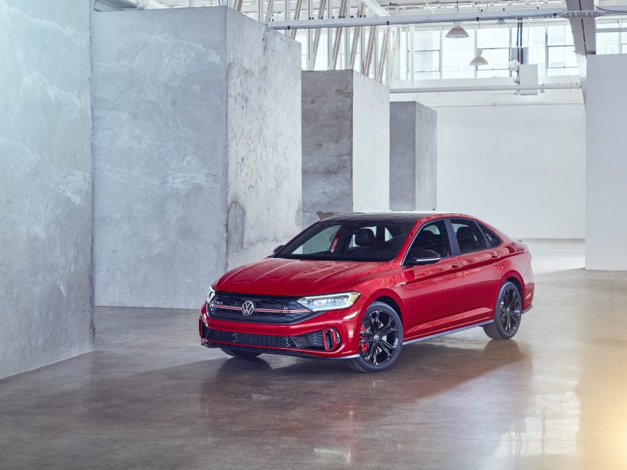 A red 2022 Volkswagen Jetta GLI shot from the front 3/4 in a warehouse