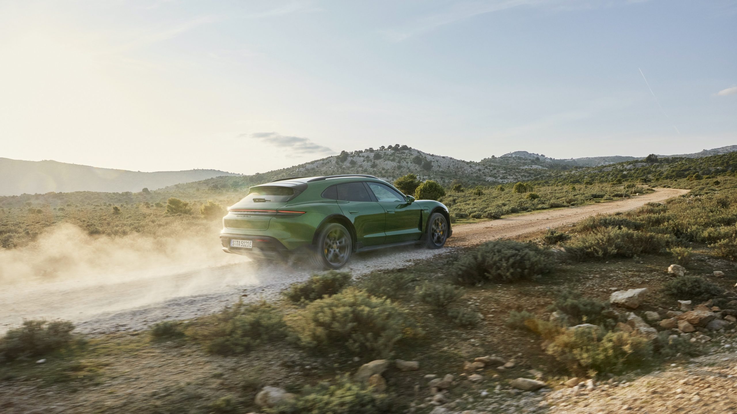 A green 2022 Porsche Taycan CrossTurismo off-road