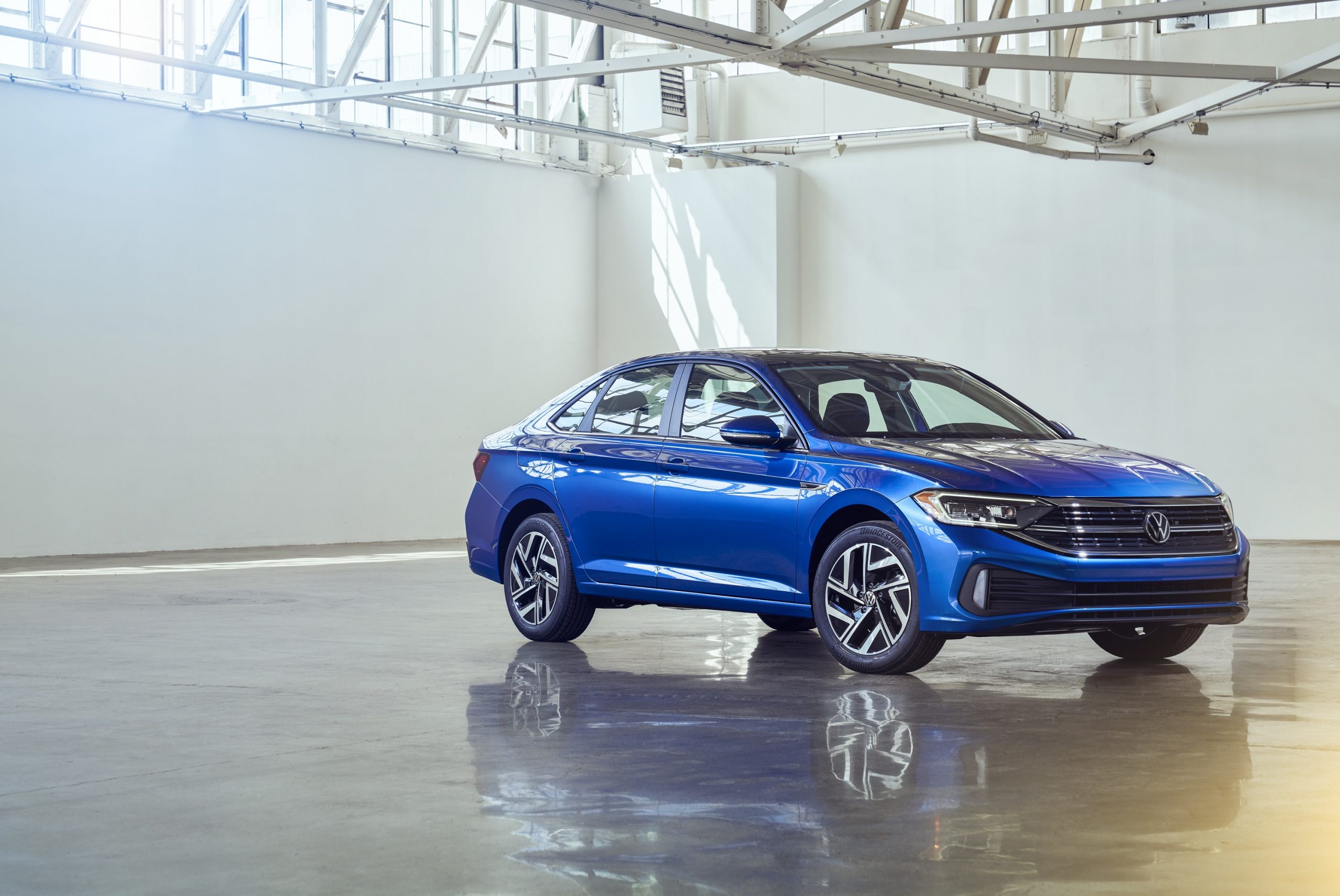 A blue 2022 Volkswagen Jetta compact car shot from the front 3/4