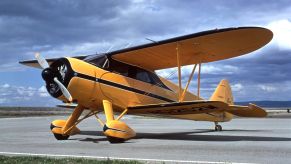 A yellow and black airplane on a runway.