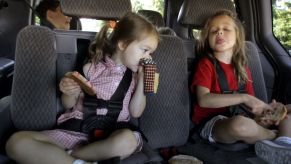 Children backseat of a car making a bad smell expression