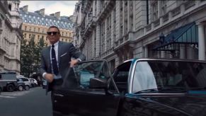 Daniel Craig's James Bond stepping out of a 1987 Aston Martin Vantage Volante V8 in London during No Time to Die