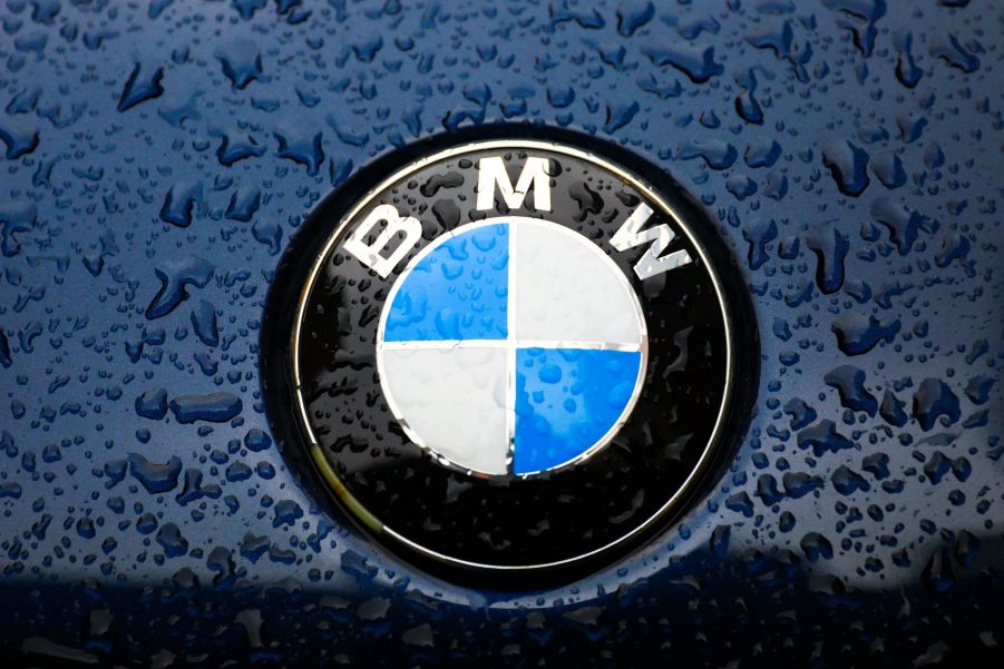 A BMW logo on a blue car with water drops on it.