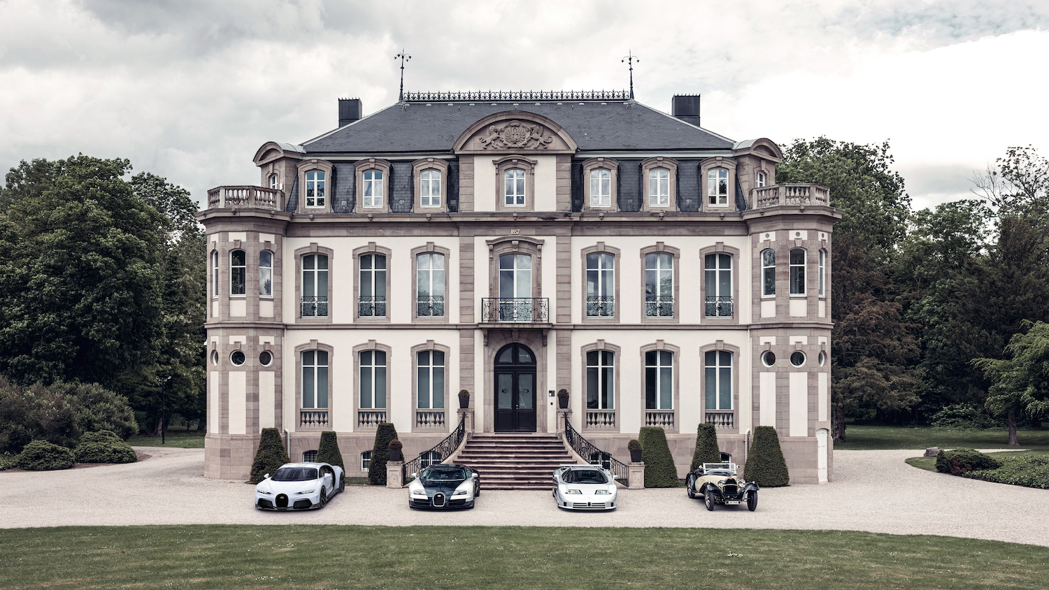 This is a photo of the Bugatti Type 55 Super Sport, the Bugatti EB110 Super Sport, the Bugatti Veyron Super Sport, and the Bugatti Chiron Super Sport, parked outside of Bugatti's headquarters in Molsheim, France. | Bugatti 