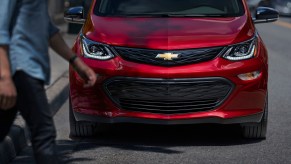 This is a promo photo of a red 2020 Chevrolet Bolt parked on the street. GM announced an additional Chevy Bolt recall, based on unsafe floormats. | General Motors