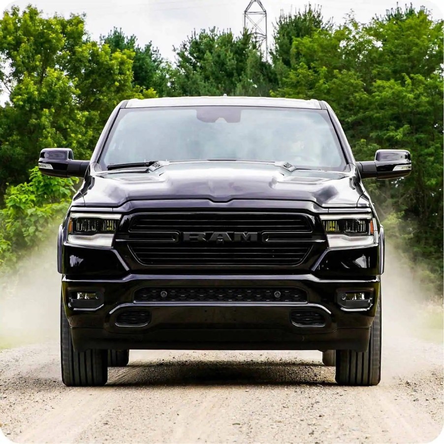 A black 2021 Ram 1500 driving through dirt.