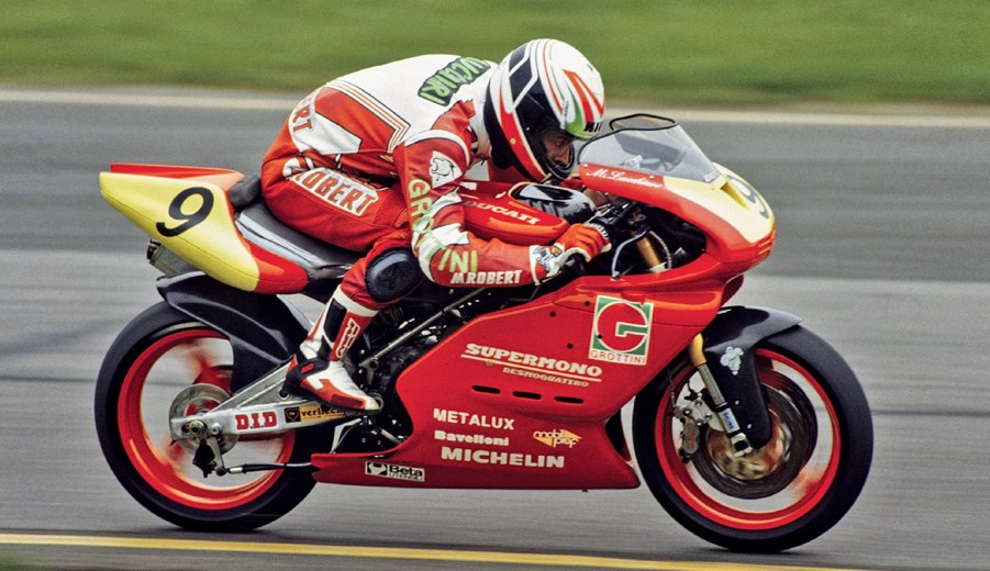 A rider racing a red-and-yellow Ducati Supermono