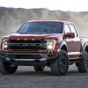 A red 2021 Ford F-150 parked on a dusty road.