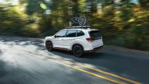 A white 2021 Subaru Forester speeding down a highway.