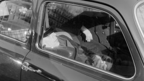 This is a photo of a man sleeping in a Volkswagen Beetle. Sleeping in your car is legal unless prohibited by local laws. | Erich Andres/United Images via Getty Images