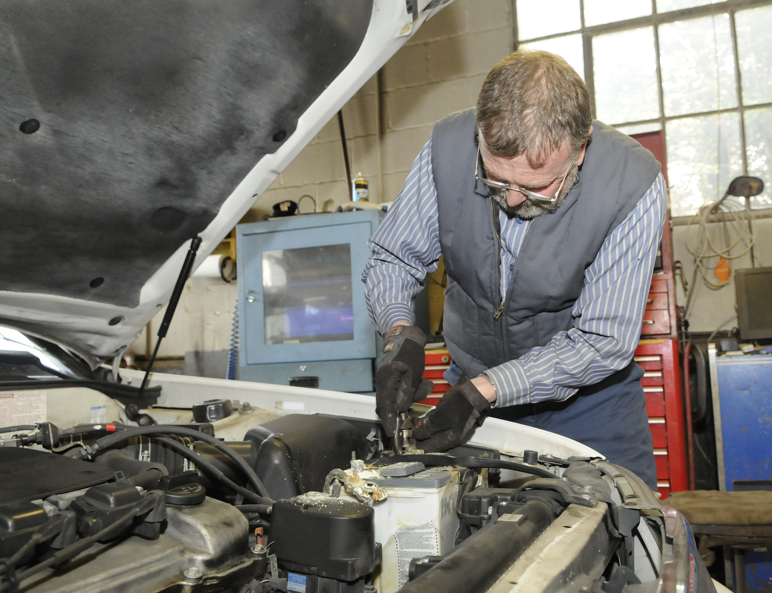 This is a photo of a mechanic disconnecting battery terminals. You may ask which terminal do you take off first, and the answer is the negative one. | Tim Leedy/MediaNews Group/Reading Eagle via Getty Images