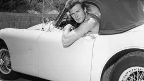 Clint Eastwood poses shirtless in his Jaguar convertible. Traffic laws do not dictate drivers' outfits. Penal laws do. Driving shirtless is not illegal wherever being shirtless in public is legal. Drivers are not exempt from public decency and indecent exposure laws. | Hulton Archive/Getty Images