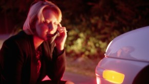 This is a photo of a woman examining the front of her sedan and calling for help. 466,000 Sonata sedans are at risk of a turn signal malfunction and affected by Hyundai recall. Doug Wilson/CORBIS/Corbis via Getty Images