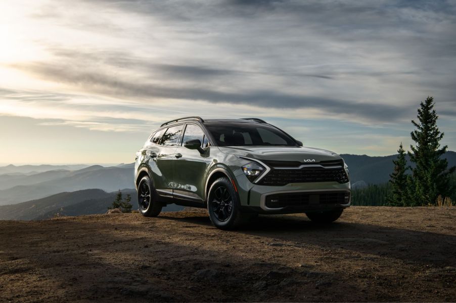 Green 2023 Kia Sportage with mountains in the background