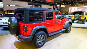 The back of a red Jeep Wrangler with a black top.