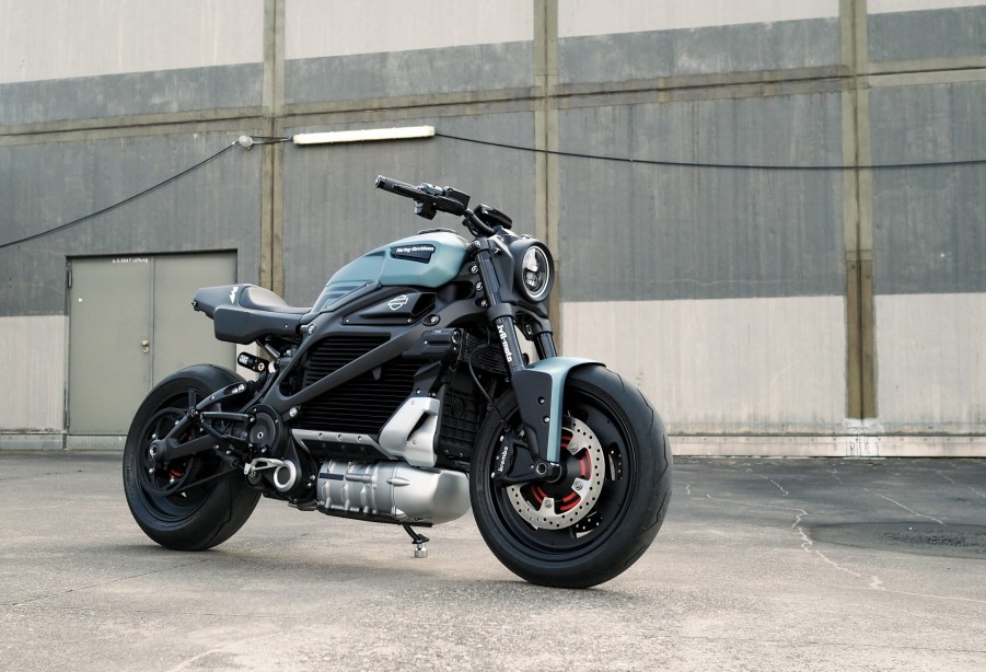 The blue-and-black JvB Moto 'Silent Alarm' custom 2020 Harley-Davidson LiveWire next to an industrial garage