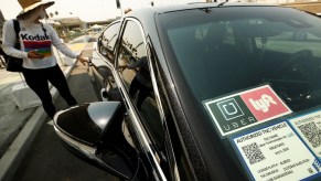 This is a photo of a woman getting into a rideshare vehicle. The Lyft and Uber safety divisions disclosed thousands of reported sexual assaults. | Al Seib/Los Angeles Times/Getty Images