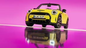 2022 Mini Cooper S convertible in yellow against a pink background