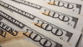 A stack of $100 bills as money spread out to symbolize financing for car buyers.