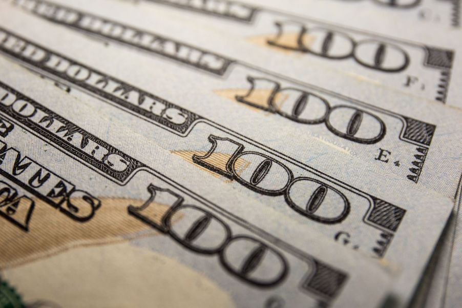 A stack of $100 bills as money spread out to symbolize financing for car buyers.